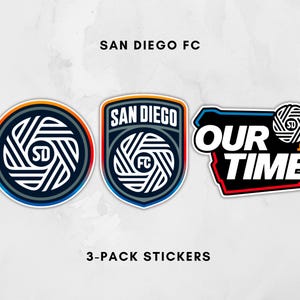May include: Three stickers featuring the San Diego FC logo. One is circular with a blue, orange, and red border. Another is shield-shaped with the team name. The third sticker reads "Our Time."