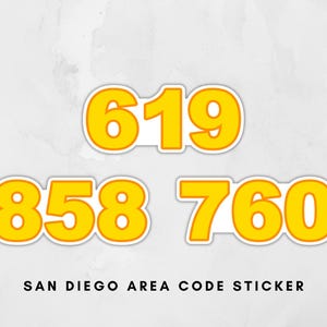 Op de afbeelding: Een witte keramische mok met een zwart handvat en de tekst "But First, Coffee" in een zwarte, handgeschreven lettertype. De mok staat op een wit oppervlak.