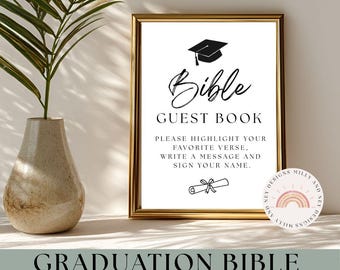 May include: A framed sign with the words "Bible Guest Book" in black script, featuring a graduation cap illustration. The sign includes instructions to highlight a favorite verse, write a message, and sign a name. The bottom of the sign reads "Graduation Bible Guest Book Sign."