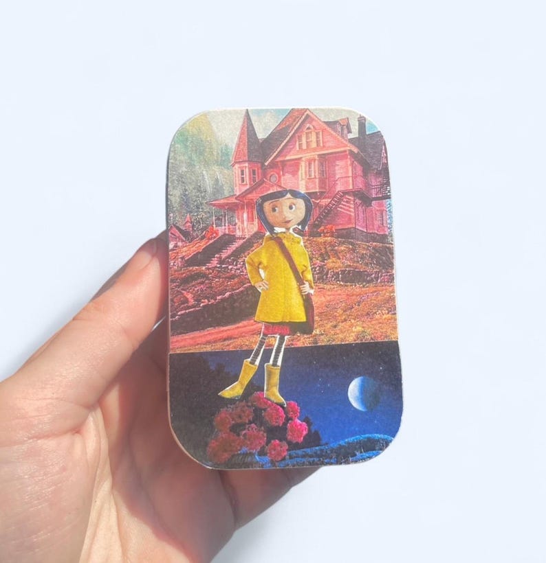 May include: A rectangular tin featuring a cartoon illustration of a girl in a yellow coat and boots, standing in front of a pink house. The background includes a night sky with a moon and a daytime scene with a house.