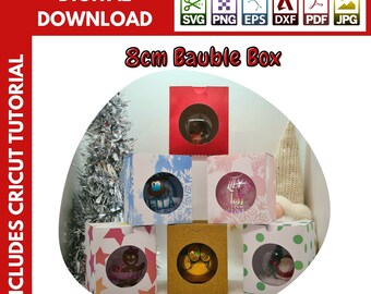 Op de afbeelding: Zes verschillende 8 cm kerstbaldozen met verschillende ontwerpen. De dozen zijn gemaakt van karton en hebben een venster om de kerstbal te tonen. De ontwerpen omvatten een sneeuwpop, een peperkoekman, een pootafdruk, een kerstman, een sneeuwvlok en een kerstboom.