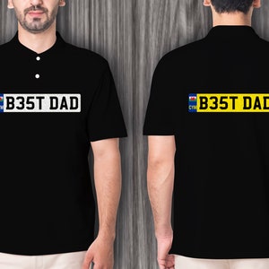 May include: Black polo shirt with a white license plate design that says "B35T DAD" with a Welsh flag on the left side of the plate.