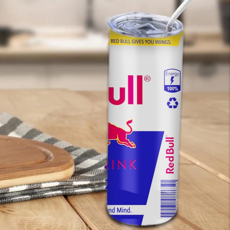 May include: A white stainless steel tumbler with a Red Bull can design. The tumbler features the Red Bull logo, a red bull, and the text "Red Bull gives you wings." and "Energy 100%".