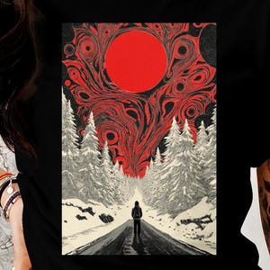 May include: Black crew neck t-shirt with a graphic print. The design shows a person on a road leading to a red sun, with white trees and a swirling red and black sky. The shirt is black.