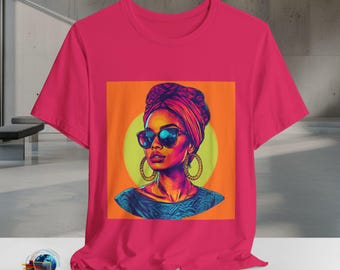 May include: A magenta t-shirt featuring a vibrant graphic of a woman wearing sunglasses and a head wrap. The artwork is set against an orange backdrop with a yellow circle, and the woman is wearing gold hoop earrings. The shirt has a crew neck.