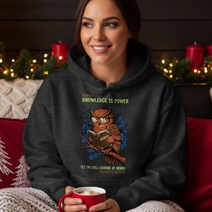 Owl wearing glasses reading book, text "Knowledge is Power" and "Yet I'm still looking at memes".