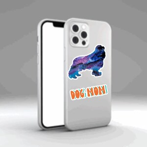 May include: A white iPhone case with a galaxy-themed dog silhouette and the text "DOG MOM" in orange and green.