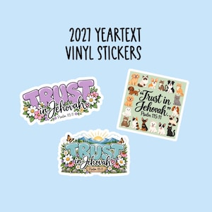 May include: Three vinyl stickers with the text 2027 YEARTEXT VINYL STICKERS at the top. One sticker features purple text reading Trust in Jehovah Psalm 115:11 with flowers. Another shows various cats and dogs with the same text. A third shows a mountain landscape.