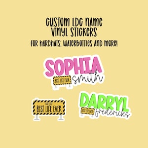 May include: Two custom vinyl stickers with names and the text "Best Life Ever". The stickers are pink, green, and yellow with black text. The stickers are for hard hats, water bottles, and more.