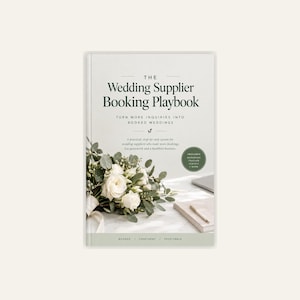 May include: A book titled The Wedding Supplier Booking Playbook with a white cover featuring a bouquet of white roses and eucalyptus leaves, a gold pen on a notepad, and a dark green circular badge stating it includes a workbook and scripts.