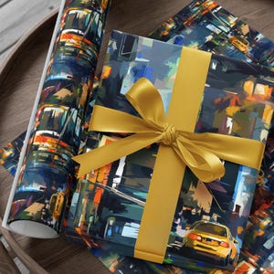 May include: A gift wrapped in blue and yellow wrapping paper with a cityscape design. The gift is tied with a gold ribbon and bow. The wrapping paper has a repeating pattern of cars and buildings.