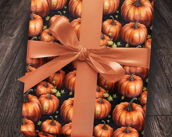 Op de afbeelding: Een ingepakt cadeau met pompoen-thema inpakpapier en een verbrand oranje lint in een strik. Het inpakpapier heeft oranje pompoenen en groene bladeren op een zwarte achtergrond. Het lint is effen van kleur.