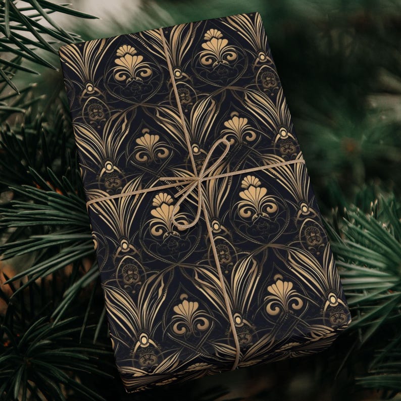 Puede incluir: Papel de regalo negro y dorado con un patr&oacute;n repetido de dise&ntilde;os florales estilizados. El papel de regalo est&aacute; atado con un lazo de cuerda marr&oacute;n.