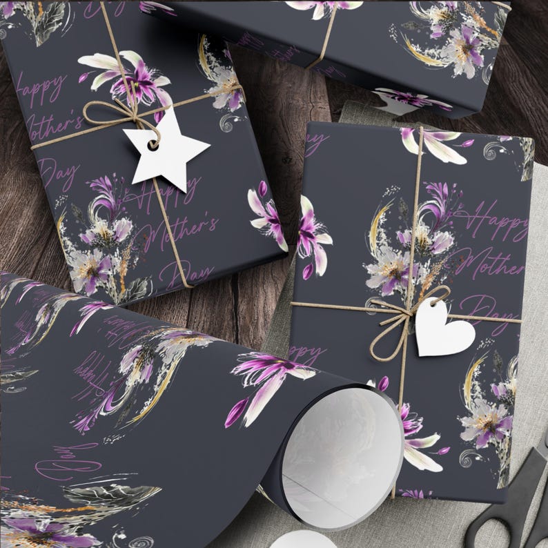 Puede incluir: Papel de regalo azul oscuro con un dise&ntilde;o floral y el texto "Happy Mother's Day" en letras rosas. El papel est&aacute; decorado con detalles blancos y dorados.