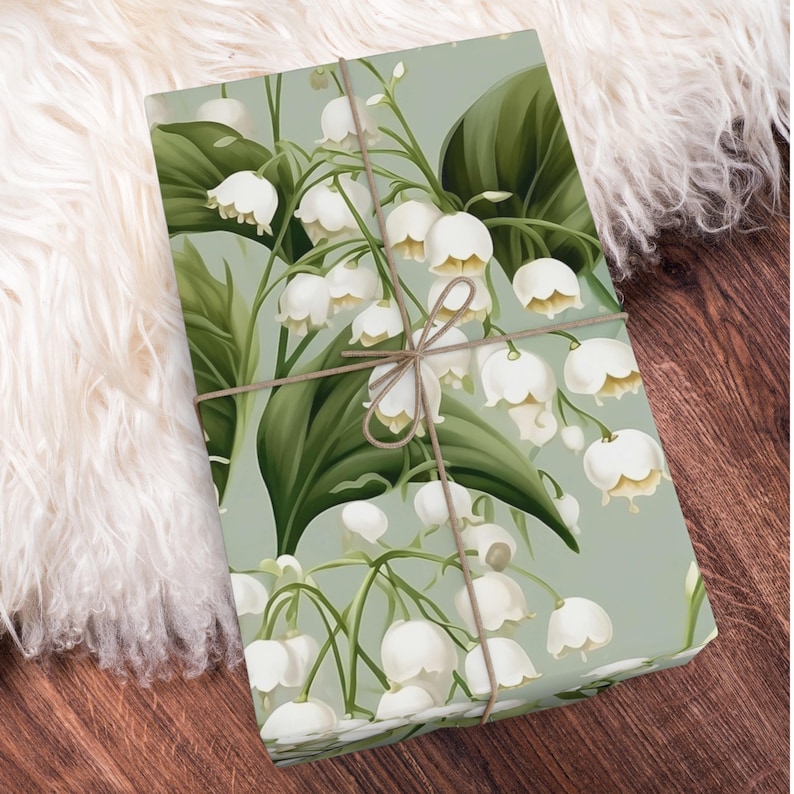 May include: A green and white floral wrapping paper with a pattern of lily of the valley flowers. The paper is tied with a brown twine bow.