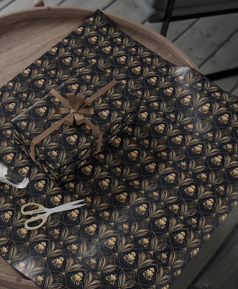 Puede incluir: Papel de regalo estampado en negro y dorado con una cinta dorada atada alrededor de una caja de regalo.