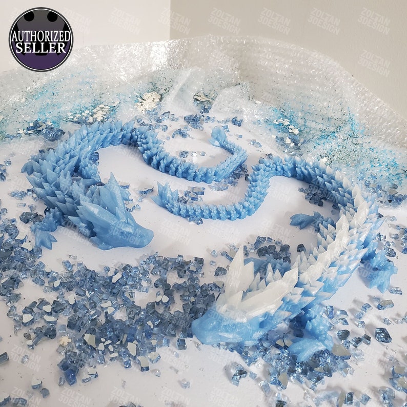 May include: Two blue and white dragon sculptures with crystal-like details. The dragons are surrounded by small, scattered blue and clear crystals. The image includes the text "AUTHORIZED SELLER" and "ZOLTAN 3DESIGN".
