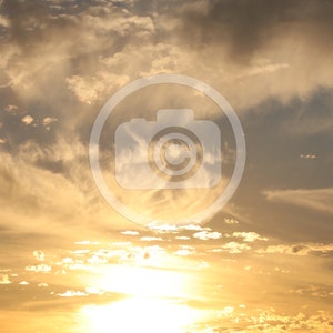 Puede incluir: Una puesta de sol dorada con nubes tenues en el cielo.