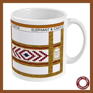 Puede incluir: Taza de cerámica blanca con un gráfico de la estación de metro Elephant & Castle de Londres. El gráfico presenta una pared de azulejos con un patrón rojo y blanco y un letrero de "Way Out".