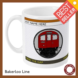 Puede incluir: Taza de cerámica blanca con un diseño de tren del metro de Londres rojo y negro. La taza tiene las palabras "ANY NAME HERE", "MIND THE GAP" y "Bakerloo Line" impresas en ella.