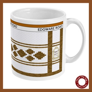 Puede incluir: Taza de cerámica blanca con un diseño marrón y blanco que presenta el texto "EDGWARE ROAD" y un letrero marrón "WAY OUT" con una flecha. La taza es una réplica de un azulejo de una estación de metro de Londres.