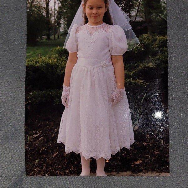 Une belle robe de première communion ou une robe de demoiselle d'honneur en dentelle blanche.