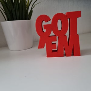 May include: Red foam letters spelling out "GOT EM" on a white surface.