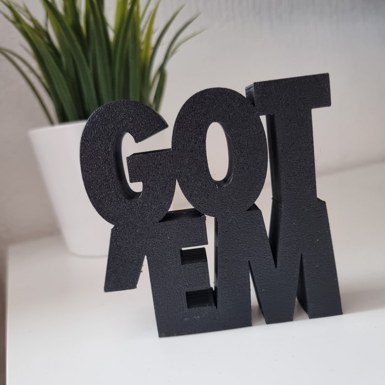 May include: Black wooden sign with the words "GOT 'EM" in bold, block letters.
