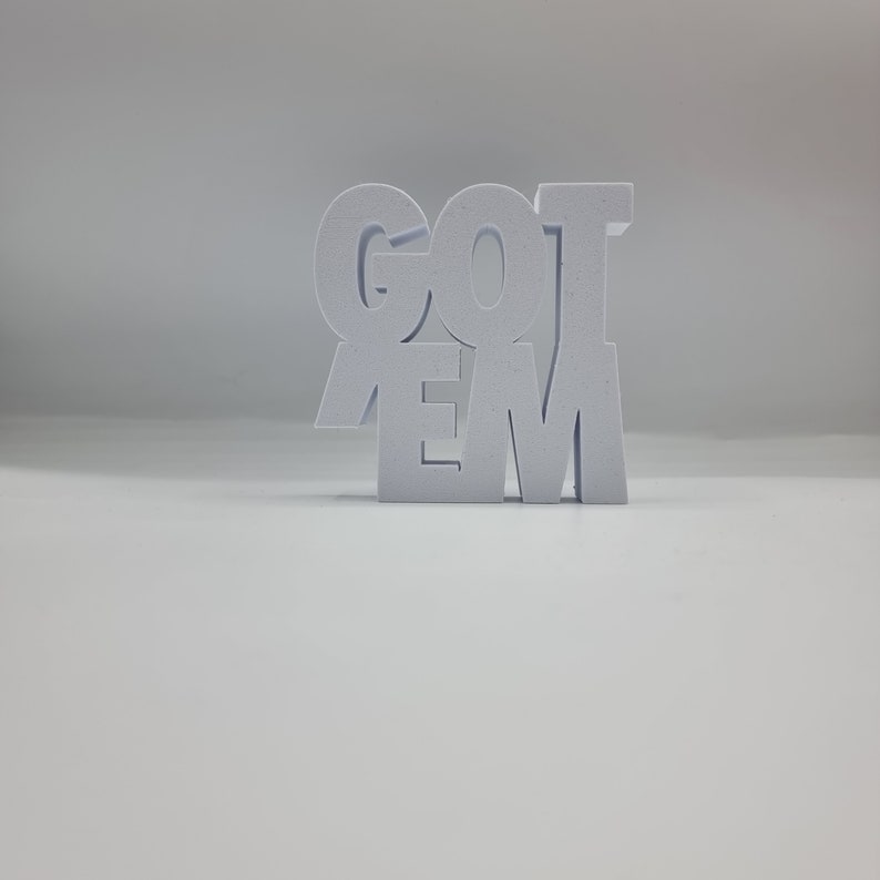 May include: White wooden block letters spelling out "GOT 'EM" on a white background.