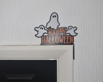 May include: A black and white Halloween decoration with three ghosts and the text "Happy Halloween" in orange letters.
