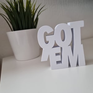 May include: White wooden sign with the words "GOT 'EM" in bold, block letters.
