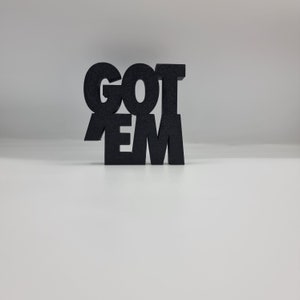 May include: Black 3D printed sign that reads "GOT 'EM".