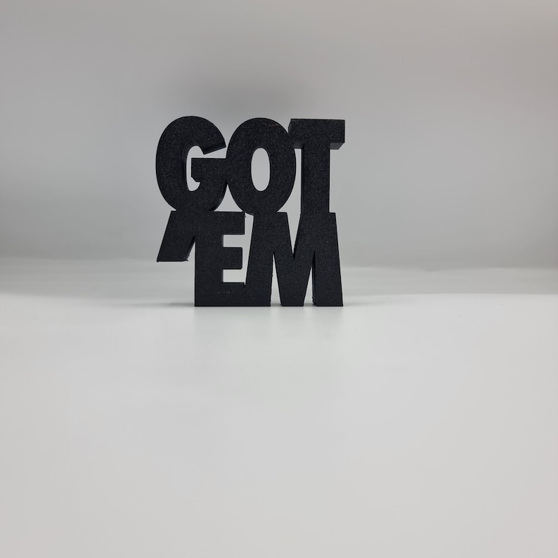 May include: Black 3D printed sign that reads "GOT 'EM".