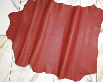 May include: A piece of red leather with a textured surface.