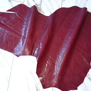 May include: A piece of burgundy leather with a textured surface.