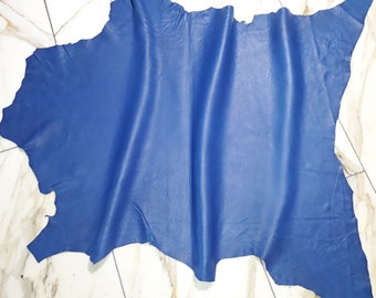 May include: A piece of blue leather with a smooth, textured surface. The leather is folded and wrinkled, showing its flexibility.