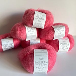 May include: A pile of seven pink yarn skeins with the label "Ballerina Chunky Mohair" on each skein.