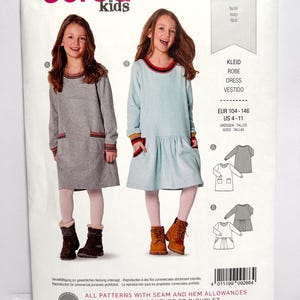 Pode incluir: Um padr&atilde;o de costura Burda Kids com duas meninas modelando vestidos. O padr&atilde;o inclui designs de vestidos com mangas compridas, bolsos e bainha com babados. O texto no padr&atilde;o diz "KLEID, ROBE, DRESS, VESTIDO" e "EUR 104-146, US 4-11".