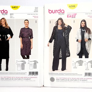 Pode incluir: Dois pacotes de padr&otilde;es de costura Burda Style. Um &eacute; rotulado 6451, apresentando um vestido preto com cinto. O outro &eacute; rotulado 6588, mostrando um macac&atilde;o e um casaco. Ambos os pacotes t&ecirc;m imagens das pe&ccedil;as de vestu&aacute;rio acabadas.