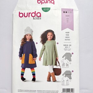 Pode incluir: Um pacote de padr&otilde;es de costura Burda Kids com ilustra&ccedil;&otilde;es de vestidos infantis. O pacote inclui o logotipo Burda Kids, o n&uacute;mero do padr&atilde;o 9310 e informa&ccedil;&otilde;es de tamanho para EUR 92-122 e US 2-7. O pacote tamb&eacute;m inclui o texto "ALL PATTERNS WITH SEAM AND HEM ALLOWANCES".
