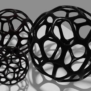 May include: Three black wire sphere sculptures of varying sizes. The spheres are made of a thick wire that is woven together to create a geometric pattern.