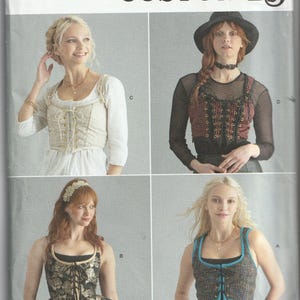 May include: Simplicity costume pattern featuring four different corset-style tops. The pattern includes sizes 14-20. The image shows various designs, including a cream-colored corset, a red and black corset, and a black and gold floral corset.