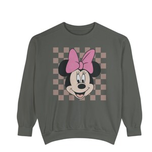 May include: A gray sweatshirt with a pink and black Minnie Mouse graphic on a checkered background.