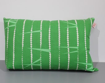 May include: A green rectangular cushion with a white geometric pattern. The cushion has a white tag on the side.