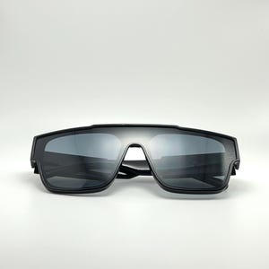 May include: Black sunglasses with a square frame and dark lenses.