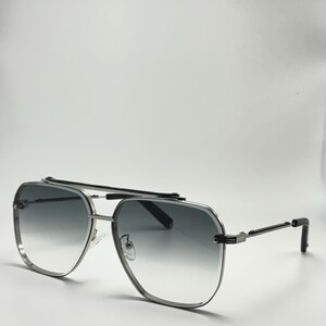 May include: Silver aviator sunglasses with a dark gray gradient lens. The sunglasses have a metal frame and a black bridge.