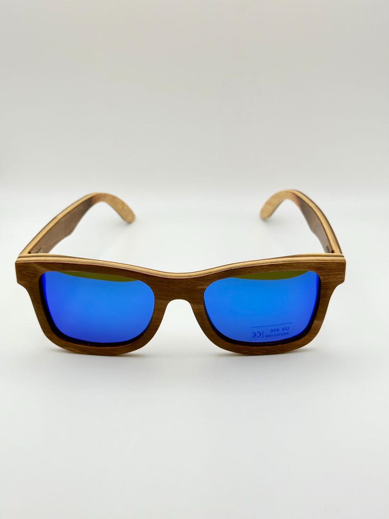 May include: Wooden-framed sunglasses with vibrant blue lenses. The frames have a natural wood grain finish, and the lenses provide UV protection. A stylish accessory for eye protection.