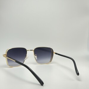 Peut inclure: Lunettes de soleil carr&eacute;es avec des montures noires et des verres gris fonc&eacute;. Les lunettes de soleil sont vues de l'arri&egrave;re.