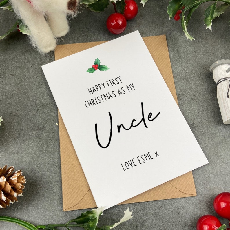 May include: White card with the text "Happy First Christmas as my Uncle" and a small holly sprig illustration. The card is signed "Love Esme x".