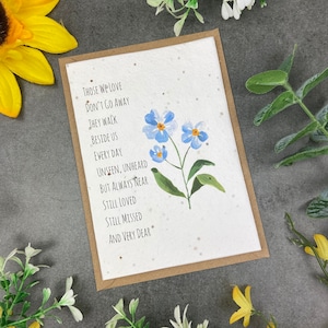 May include: A sympathy card with a blue forget-me-not flower illustration and the text "Those we love don't go away they walk beside us every day unseen, unheard but always near still loved still missed and very dear."
